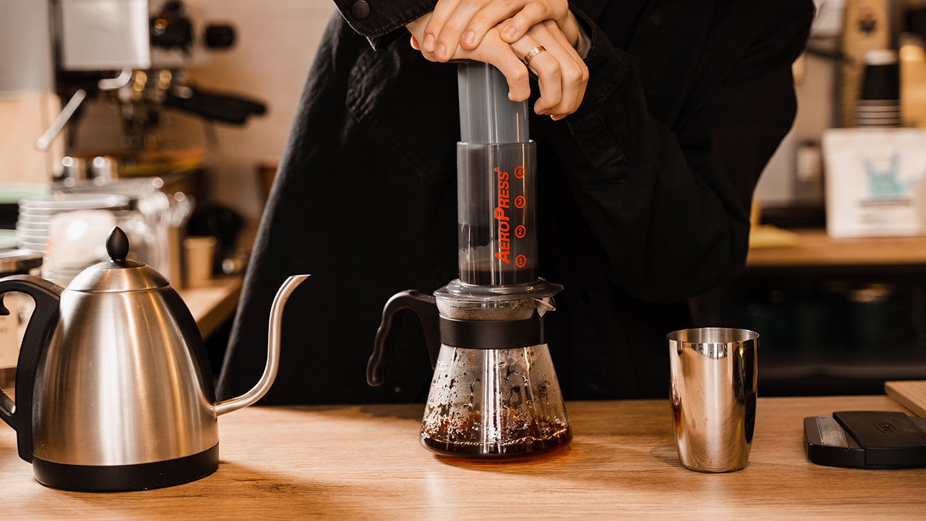 AeroPress Coffee with Barista Pushing Down the Plunger