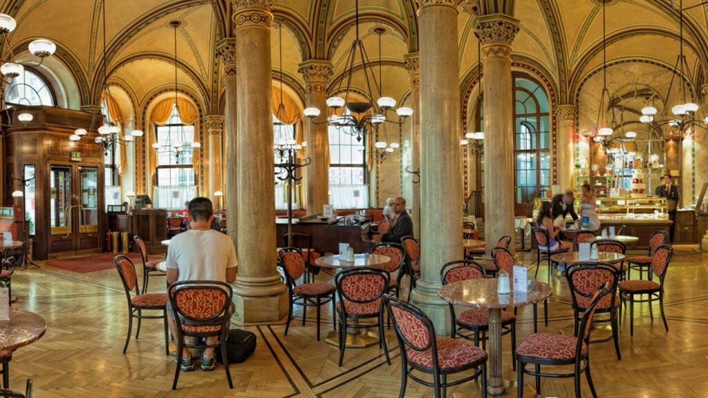 Caffeine and Culture — Inside Vienna’s Historic Cafe Central Caffeine and Culture — Elegant Interior of Cafe Central in Vienna with Guests Enjoying the Ambiance.