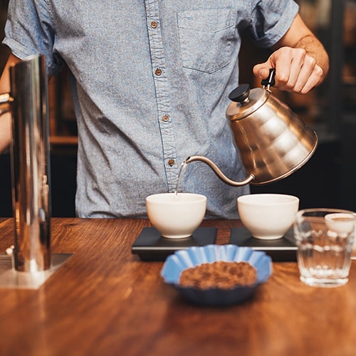 Pouring Hot Water Over Coffee for a Cupping Session
