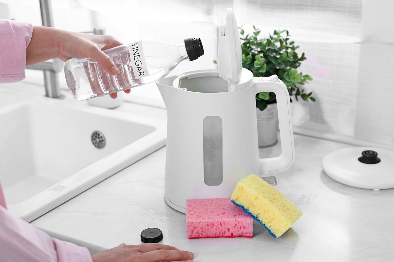 Coffee Gear Problems — Using Vinegar for Descaling Pouring Vinegar into an Electric Kettle for Descaling