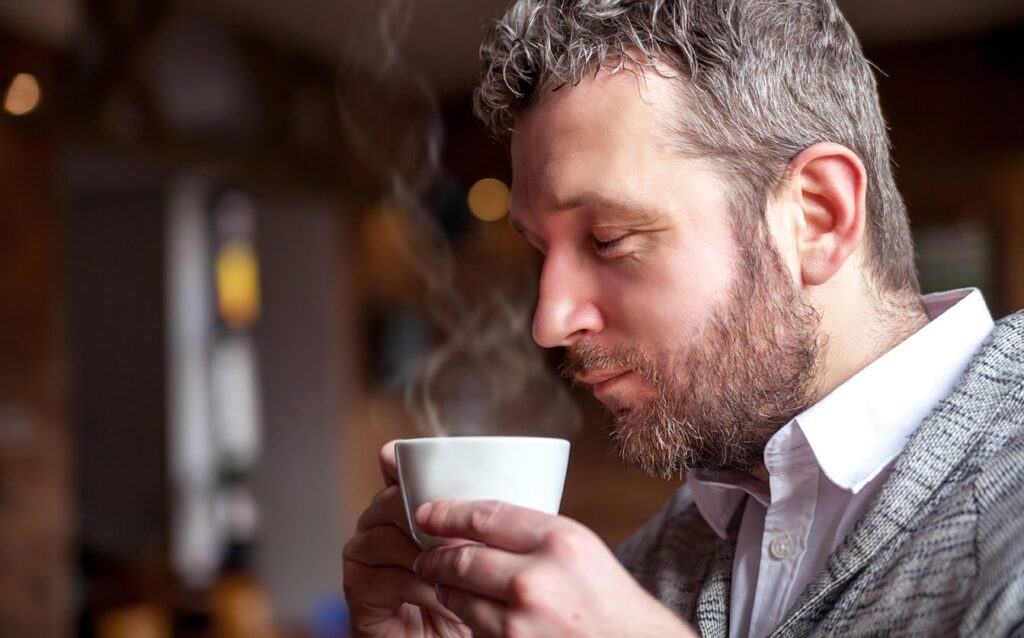 Coffee Tasting for Beginners — Man Savoring the Aroma of Freshly Brewed Coffee