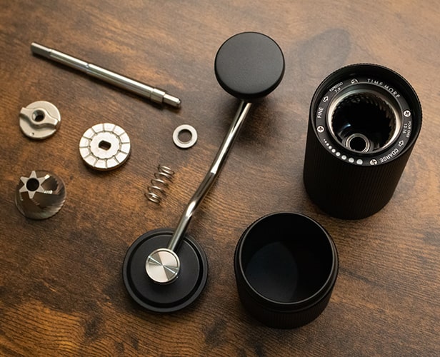 A Disassembled Parts of a Manual Coffee Grinder on a Table