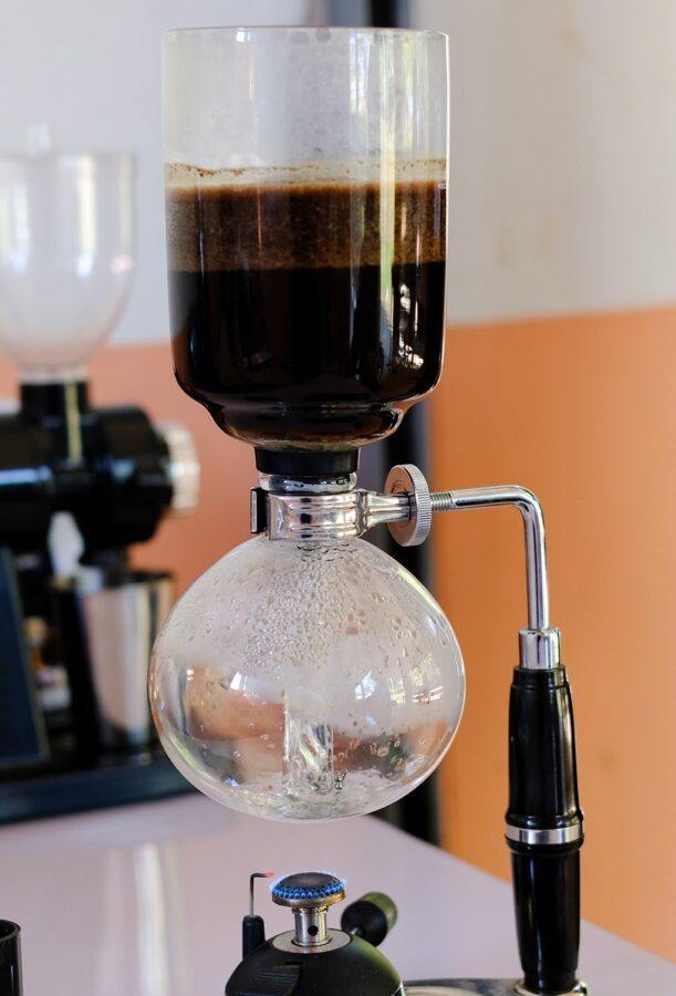 A Siphon Coffee Maker With Coffee Grounds Steeping in the Upper Chamber
